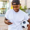 Football bettor checking a phone and setting responsible betting limits