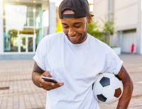 Football bettor checking a phone and setting responsible betting limits
