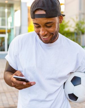 Football bettor checking a phone and setting responsible betting limits