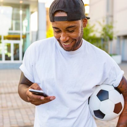Football bettor checking a phone and setting responsible betting limits