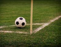 Football beside a corner flag for football betting analysis