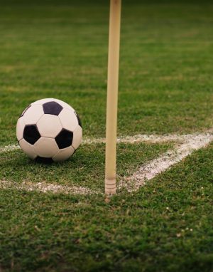 Football beside a corner flag for football betting analysis