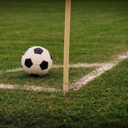 Football beside a corner flag for football betting analysis
