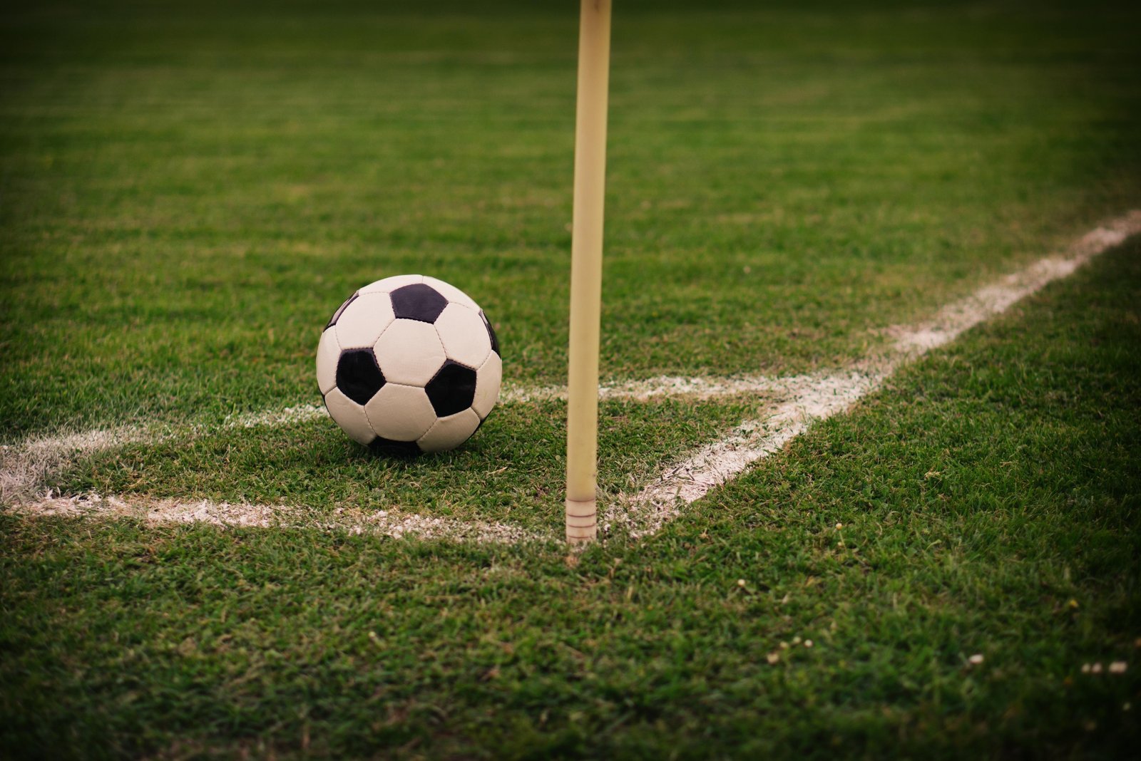 Football beside a corner flag for football betting analysis